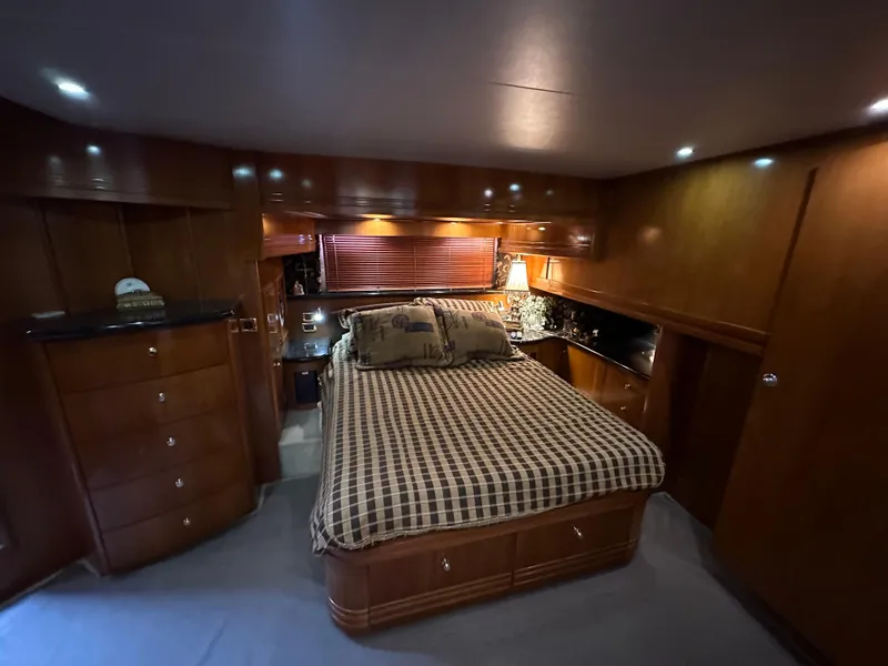 Slide: The Image of Luxurious bedroom interior of 2001 Carver 570 Voyager Pilothouse yacht with wooden cabinetry. - 12