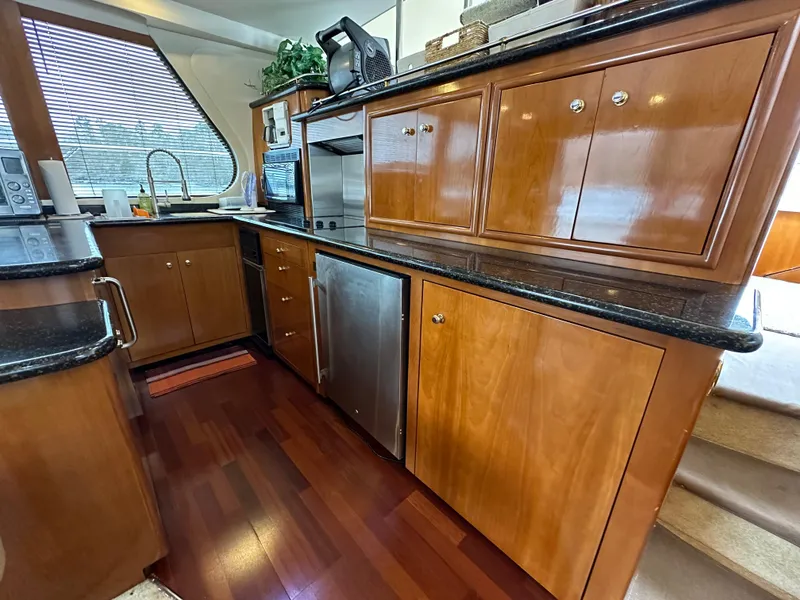 Slide: The Image of Luxurious kitchen area in a 2001 Carver 570 Voyager Pilothouse yacht with wooden cabinetry. - 9