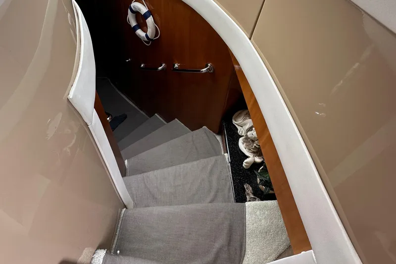 Slide: The Image of Staircase inside 2001 Carver 570 Voyager Pilothouse yacht with carpeted steps and wooden walls. - 23