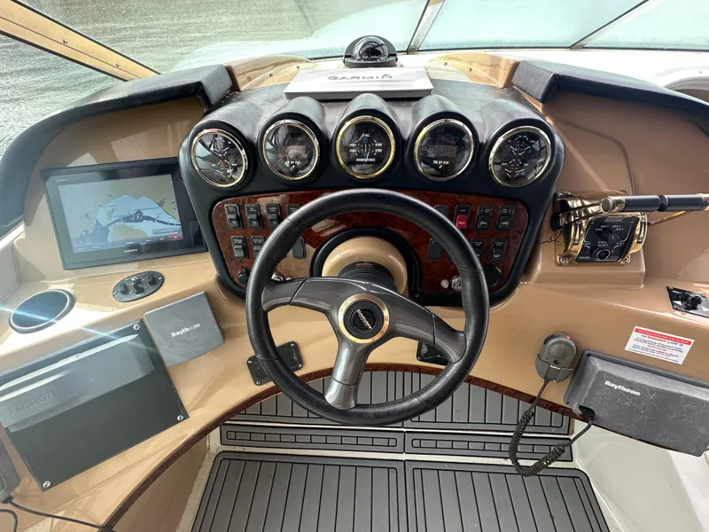 Slide: The Image of 2001 Carver 570 Voyager Pilothouse helm with steering wheel, gauges, and navigation equipment. - 5