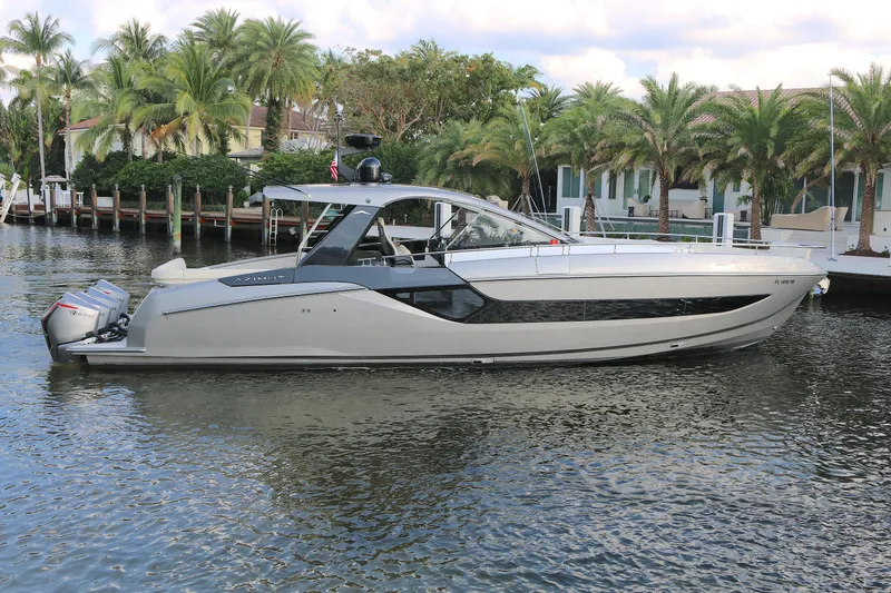 The Image of 2022 Azimut 47 VERVE luxury yacht on a serene waterfront with palm trees. - 0