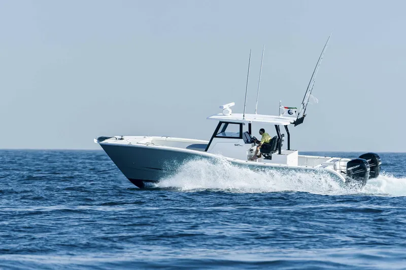 Slide: The Image of 2025 SilverCAT 34 CC boat cruising on open water, two people onboard, clear sky. - 11
