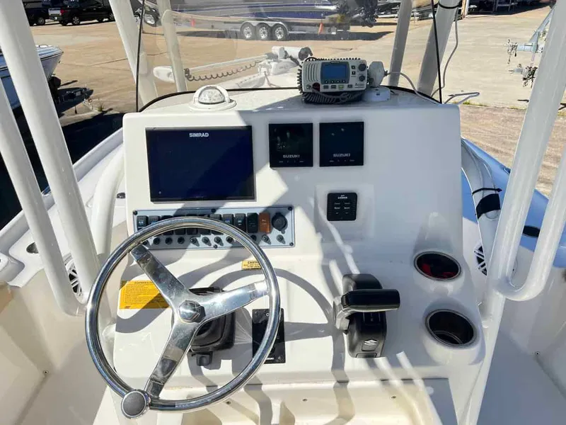 Slide: The Image of 2019 Key West 230 Bay Reef boat dashboard with steering wheel and navigation controls. - 9