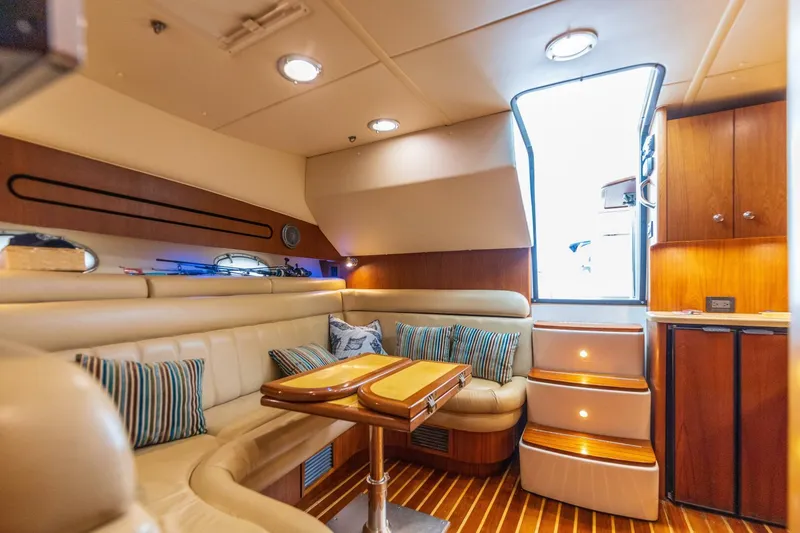 Slide: The Image of Interior of 2004 Tiara Yachts 38 Express with plush seating and wooden accents. - 14