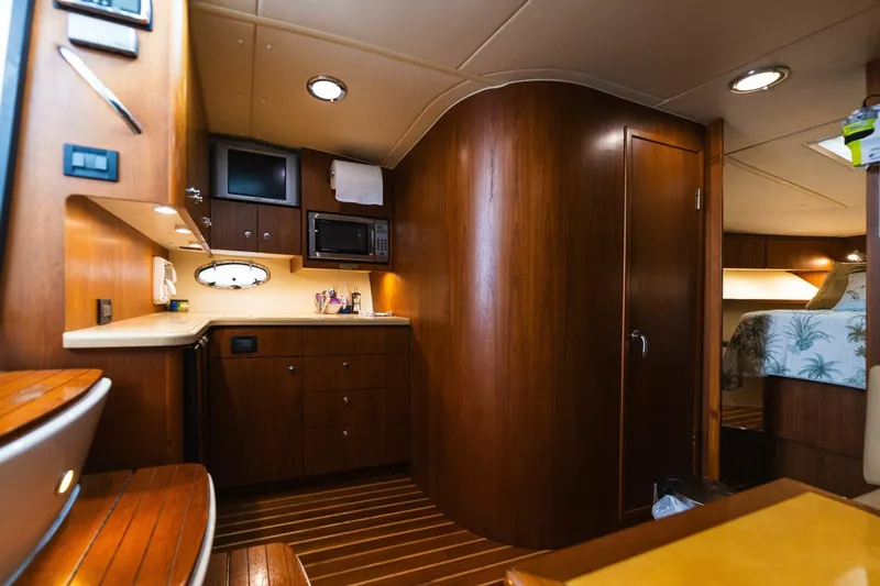 Slide: The Image of Interior of a 2004 Tiara Yachts 38 Express, featuring a cozy kitchen and wooden cabinetry. - 18