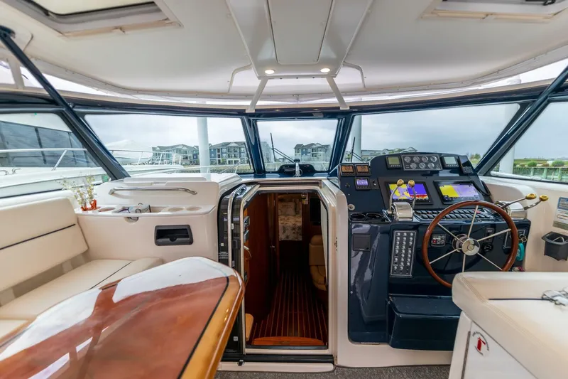 Slide: The Image of 2004 Tiara Yachts 38 Express helm station with wooden steering wheel and navigation equipment. - 3