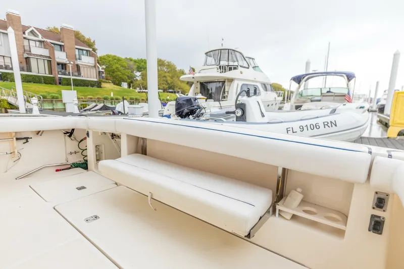 Slide: The Image of 2004 Tiara Yachts 38 Express at a marina, featuring a spacious deck and seating. - 34