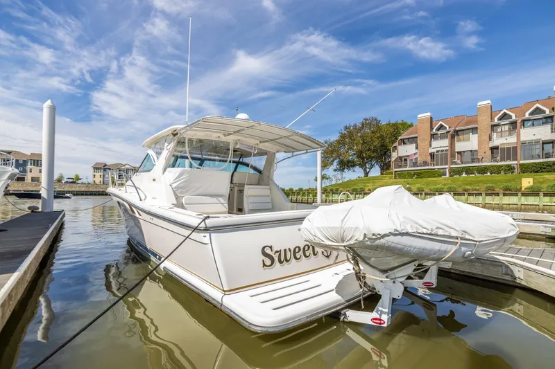 Slide: The Image of 2004 Tiara Yachts 38 Express docked, rear view with covered dinghy, Sweet on stern. - 36