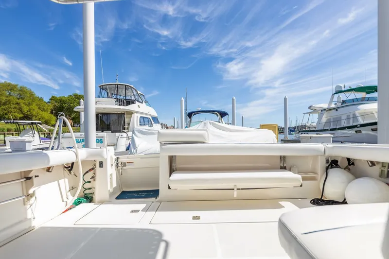 Slide: The Image of 2004 Tiara Yachts 38 Express at marina, showcasing spacious deck and seating area. - 40