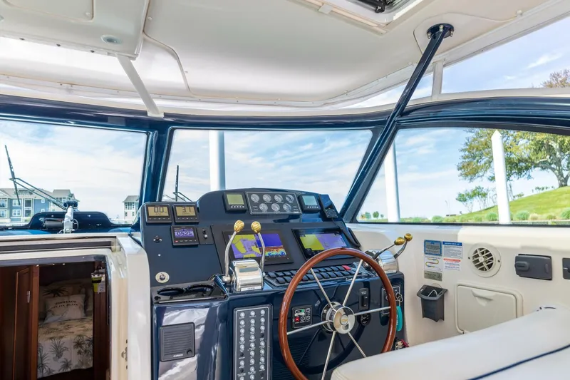 Slide: The Image of 2004 Tiara Yachts 38 Express helm station with navigation instruments and steering wheel. - 41