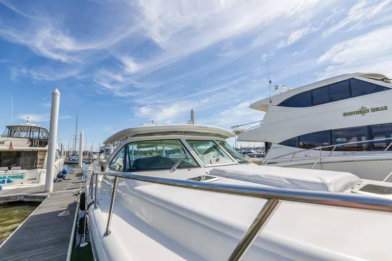 Slide: The Image of 2004 Tiara Yachts 38 Express docked at a marina under a clear sky. - 46