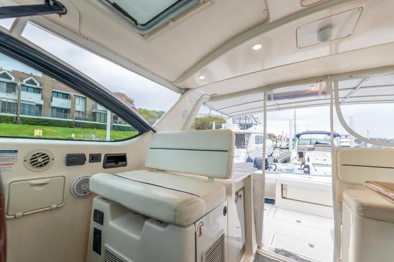 Slide: The Image of Interior of a 2004 Tiara Yachts 38 Express, featuring seating and dock view. - 7