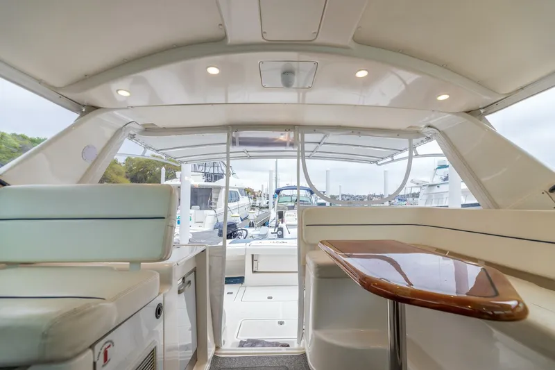 Slide: The Image of 2004 Tiara Yachts 38 Express interior with seating and table, docked at marina. - 8