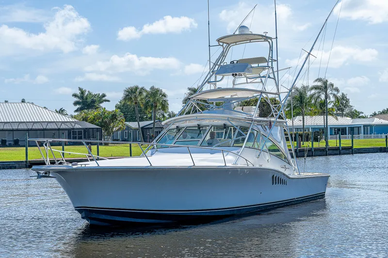 The Image of 2005 Albemarle 410 boat cruising on a sunny day in a residential canal. - 0