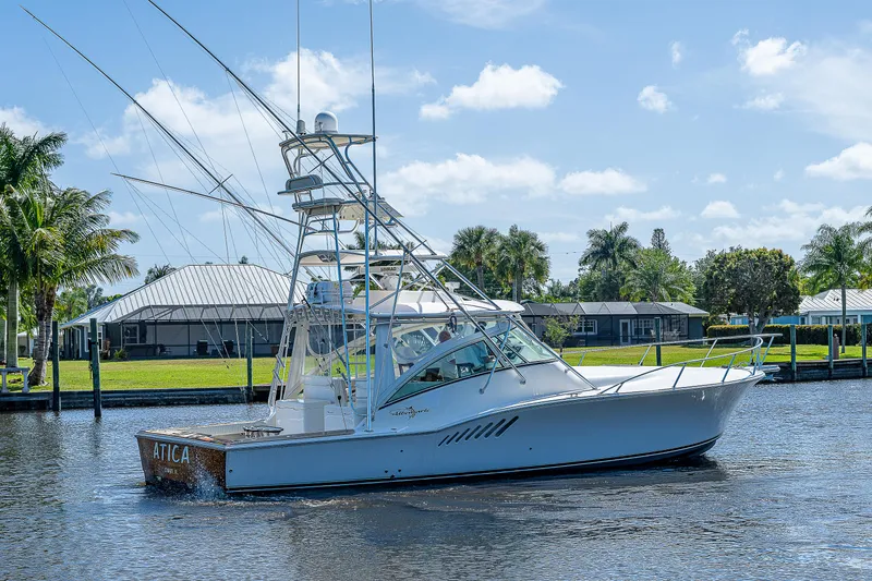 Slide: The Image of 2005 Albemarle 410 boat cruising on a sunny day near waterfront homes. - 10