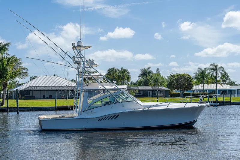 Slide: The Image of 2005 Albemarle 410 boat on a sunny day, docked near waterfront homes. - 11