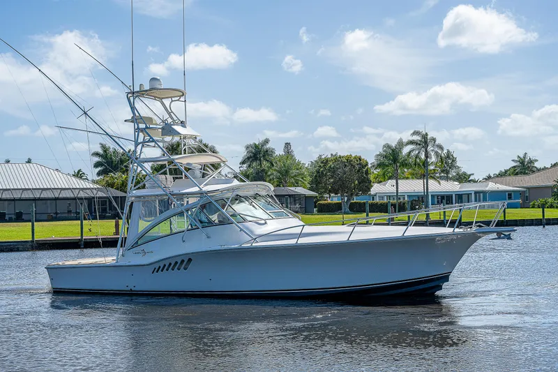Slide: The Image of 2005 Albemarle 410 boat cruising on a sunny day with waterfront homes in the background. - 13