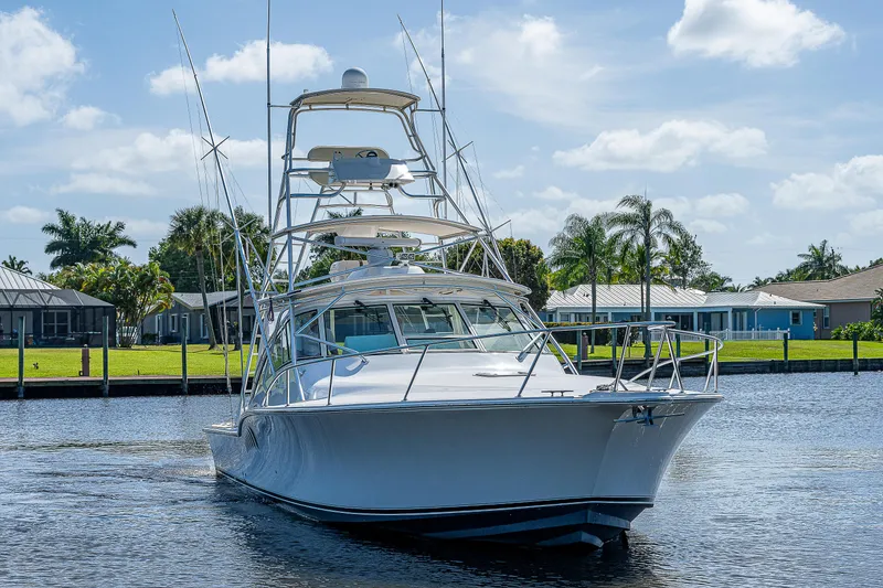 Slide: The Image of 2005 Albemarle 410 boat cruising on a sunny day near waterfront homes. - 16