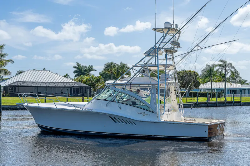 Slide: The Image of 2005 Albemarle 410 boat cruising on a sunny day near waterfront homes. - 22