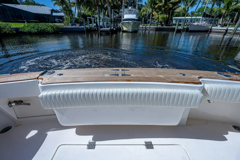 Slide: The Image of 2005 Albemarle 410 boat stern view with cushioned seating and water backdrop. - 28
