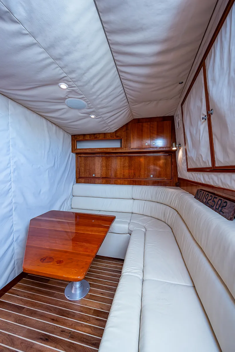 Slide: The Image of 2005 Albemarle 410 yacht interior with white leather seating and wooden table. - 46