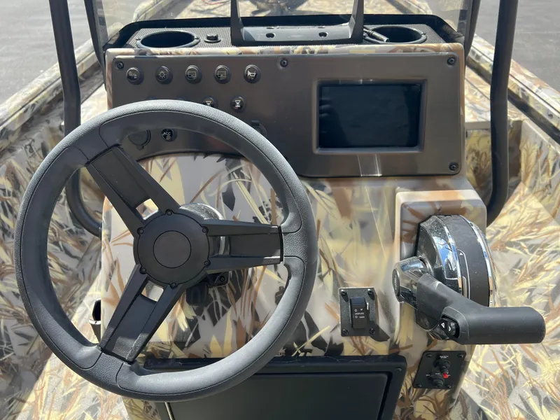 Slide: The Image of 2024 Ranger RB210 boat console with steering wheel, control panel, and display screen. - 10