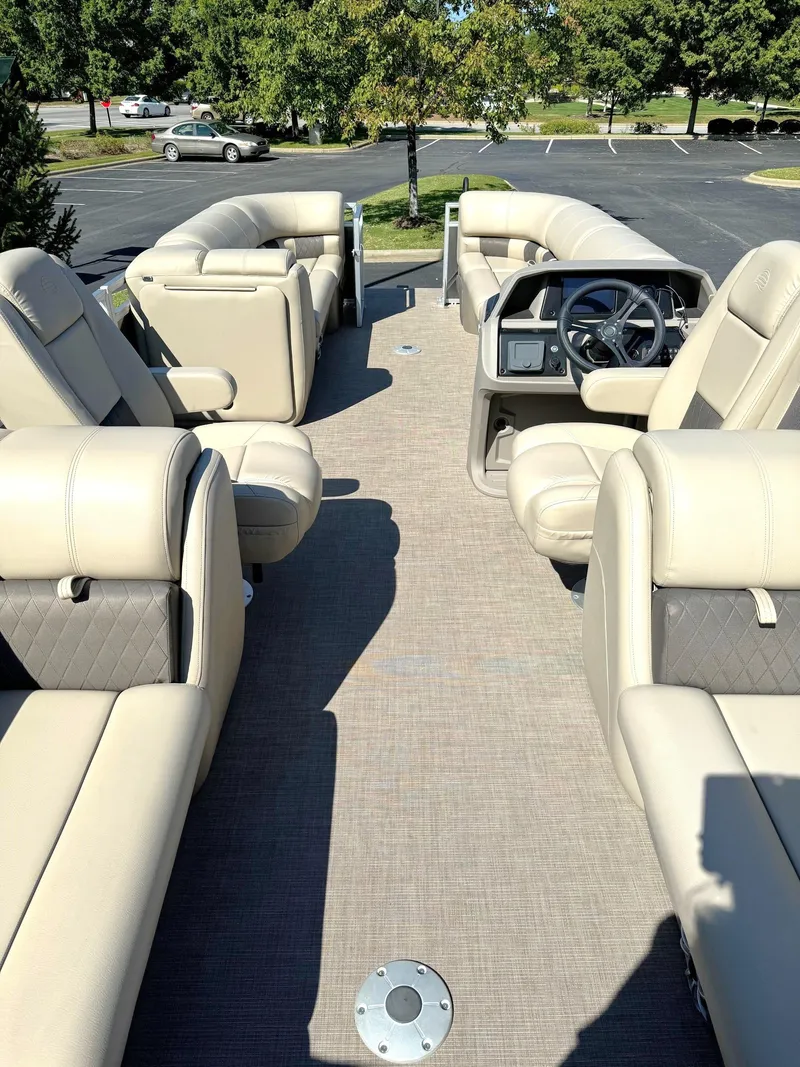 Slide: The Image of 2024 Sun Tracker Party Barge 24 DLX interior with plush seating and steering console. - 4