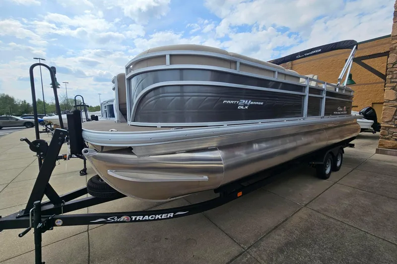 Slide: The Image of 2024 Sun Tracker Party Barge 24 DLX pontoon boat on trailer, parked outdoors. - 57