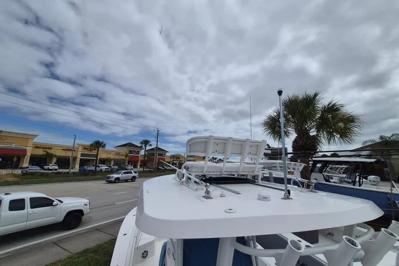 Slide: The Image of 2024 Regulator 30XO boat displayed outdoors near a shopping center under cloudy skies. - 10