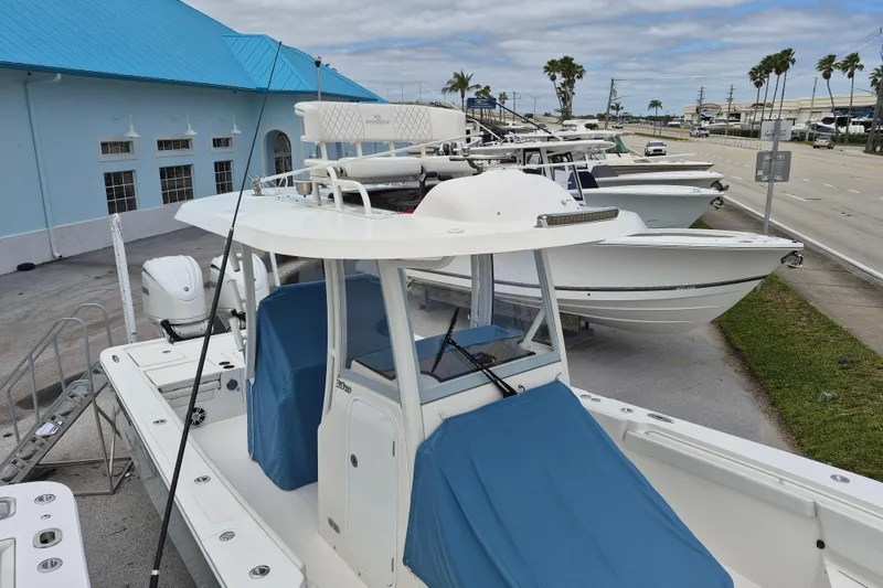 Slide: The Image of 2024 Regulator 30XO boat with blue covers, docked near a blue building. - 12