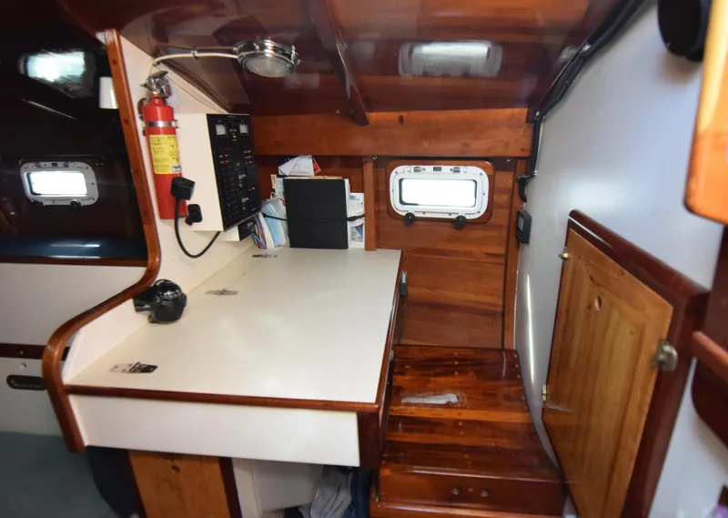Slide: The Image of Interior of 2000 Custom Tumbleweed Cutter, featuring wooden cabinetry and navigation station. - 11