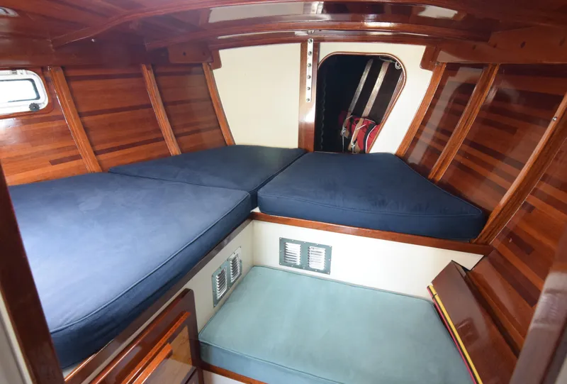 Slide: The Image of Cozy cabin interior of 2000 Custom Tumbleweed Cutter with wooden paneling and blue cushions. - 14
