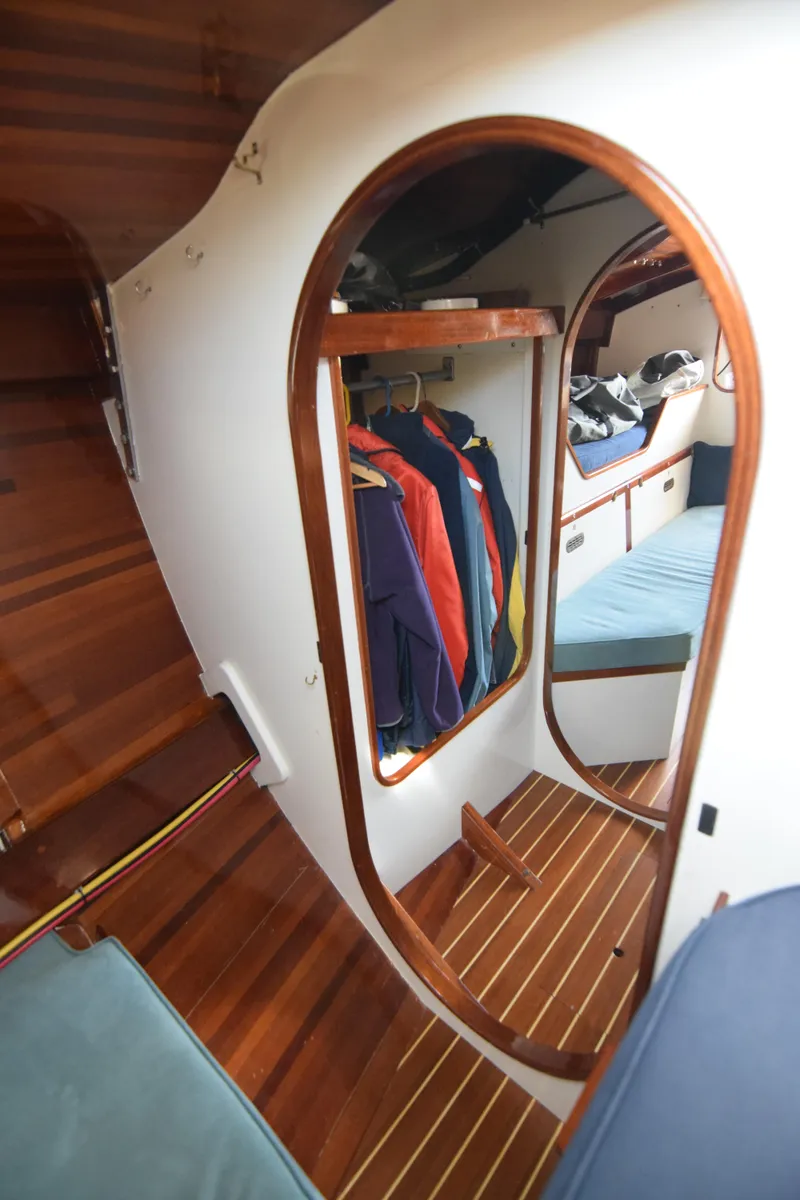 Slide: The Image of Interior of 2000 Custom Tumbleweed Cutter with wooden finish and hanging clothes. - 16