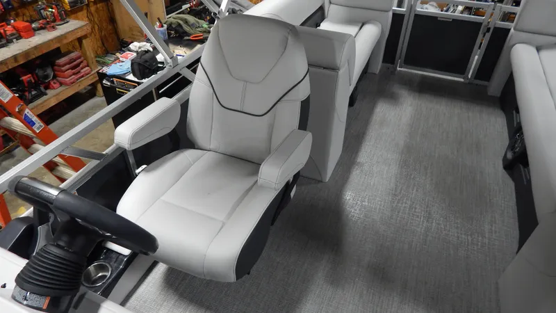 Slide: The Image of 2024 Avalon VLS Quad Lounge 21' boat interior with captain's chair and steering wheel. - 4