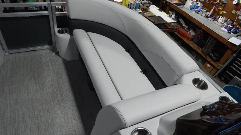 Slide: The Image of 2024 Avalon VLS Quad Lounge 21' interior seating area with cup holders. - 6