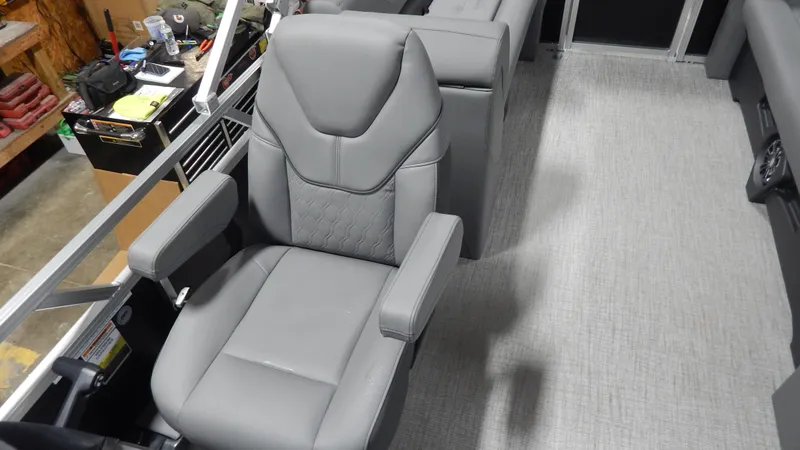 Slide: The Image of 2024 Avalon VLS Quad Lounge 21' interior with gray captain's chair and armrests. - 2