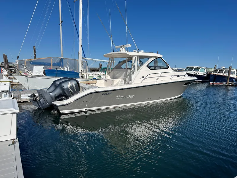 Slide: The Image of 2017 Pursuit OS 355 boat docked in marina under clear blue sky. - 1