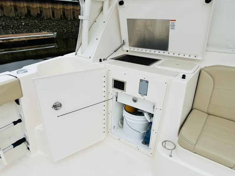 Slide: The Image of 2017 Pursuit OS 355 boat interior with storage compartment and seating. - 12