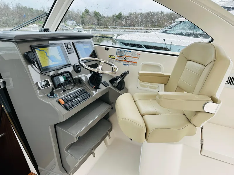 Slide: The Image of 2017 Pursuit OS 355 helm with navigation screens and captain's chair. - 14