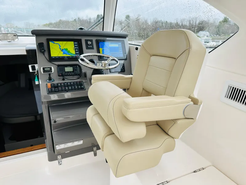 Slide: The Image of Captain's chair and helm of a 2017 Pursuit OS 355 boat with navigation screens. - 15