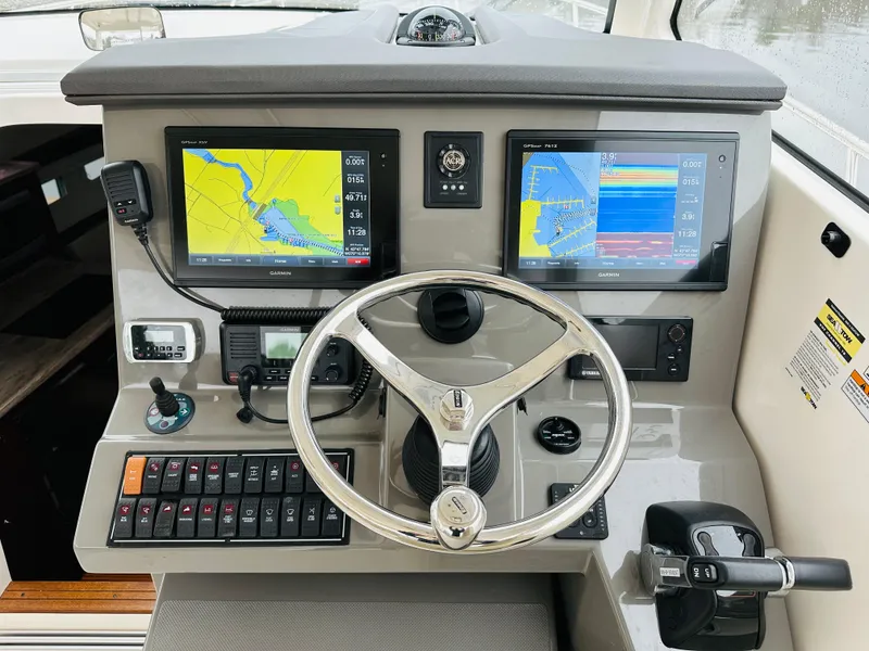 Slide: The Image of 2017 Pursuit OS 355 boat helm with dual navigation screens and control panel. - 16