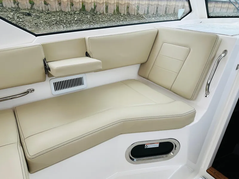 Slide: The Image of 2017 Pursuit OS 355 boat interior with beige leather seating. - 23