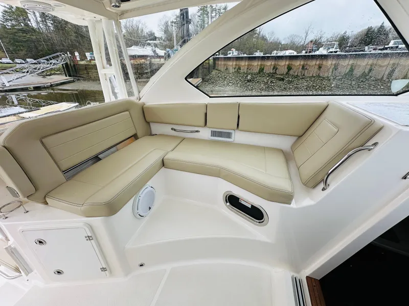 Slide: The Image of 2017 Pursuit OS 355 boat interior with beige leather seating. - 24