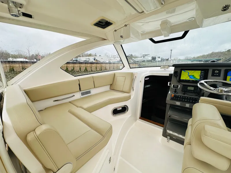 Slide: The Image of 2017 Pursuit OS 355 boat interior with beige seating and modern navigation system. - 25