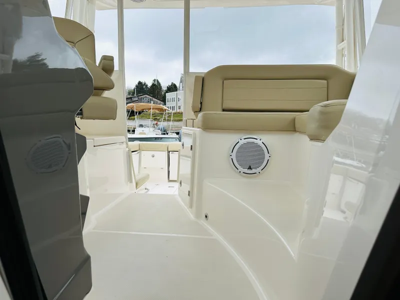 Slide: The Image of 2017 Pursuit OS 355 boat interior with beige seating and speaker. - 26