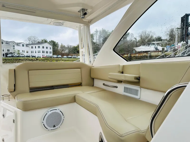 Slide: The Image of 2017 Pursuit OS 355 boat interior with beige seating and waterfront view. - 27
