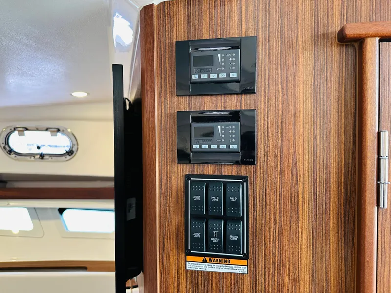 Slide: The Image of Control panel on 2017 Pursuit OS 355 boat with wood finish. - 31