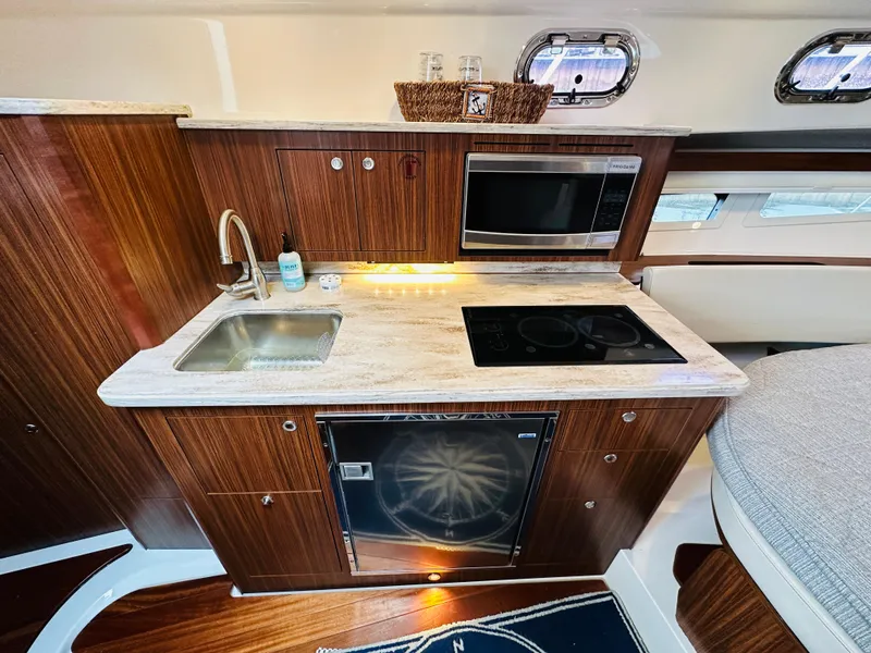 Slide: The Image of Modern galley kitchen in 2017 Pursuit OS 355 boat with sink, stove, and microwave. - 32