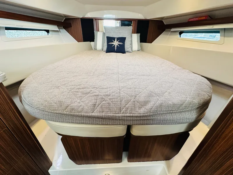 Slide: The Image of 2017 Pursuit OS 355 cabin with a cozy bed and nautical-themed pillow. - 33