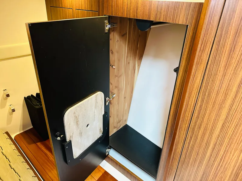 Slide: The Image of Open storage compartment in 2017 Pursuit OS 355 boat with wooden interior. - 38